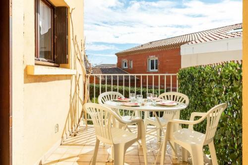 un patio avec une table et des chaises sur un balcon dans l'établissement Valras-Loc T2 spacieux et calme au coeur de Valras, à Valras-Plage