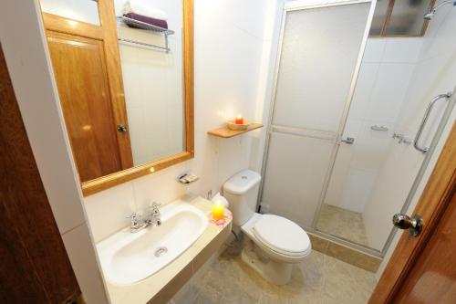 a bathroom with a toilet and a sink and a shower at Maison Fortaleza in Cusco