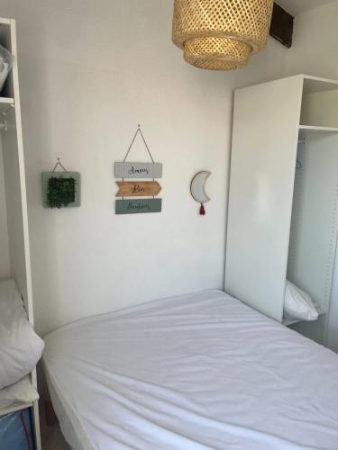 une chambre avec un lit blanc dans une pièce dans l'établissement Valras-Loc Maison des Orangers, à Valras-Plage