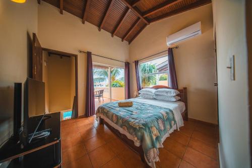 a bedroom with a bed and a flat screen tv at Appartement 8 & 9- Lagun blou resort - Curaçao in Lagun