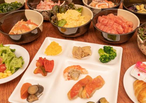 a table with plates of food and bowls of vegetables at LiVEMAX RESORT Atami OCEAN in Atami