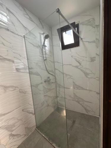 a bathroom with a shower with a glass door at Horizon Hills Cottage- ჰორიზონ ჰილს in Kvariati