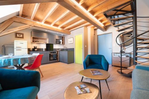 un salon avec un canapé bleu et des chaises et un escalier en colimaçon dans l'établissement 8 - Seigneurie Fouquet - Tousquet, au Palais