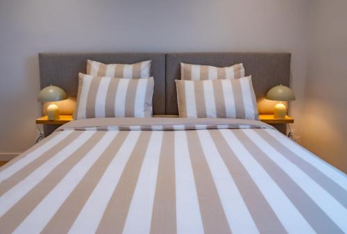 - une chambre avec un grand lit et des oreillers rayés dans l'établissement #101-Heart of Vieil Antibes - Place Nationale-High-End Newly Renovated & Furnished Appartment, à Antibes