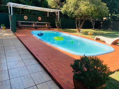 una piscina in un cortile con tavolo e panca di Casa Nina, com Piscina e Brinquedoteca, Super Próxima das Cataratas e Aeroporto a Foz do Iguaçu