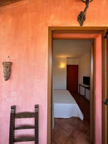 a room with a bedroom with a bed and a chair at da Bonny in Villasimius