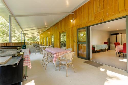 une cuisine et une salle à manger avec tables et chaises dans l'établissement Gite l'Ecurie de l'Etrier, à Vitrac