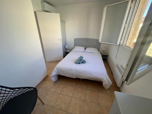 une petite chambre avec un lit et une fenêtre dans l'établissement Valras-Loc Maison T3, à Valras-Plage
