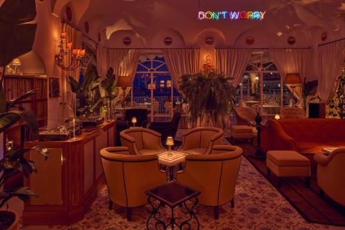 a salon with chairs and a bar in a room at Le Sirenuse in Positano