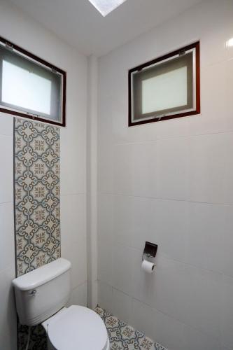 a bathroom with a toilet and two windows at Tubtim Resort in Ko Samed