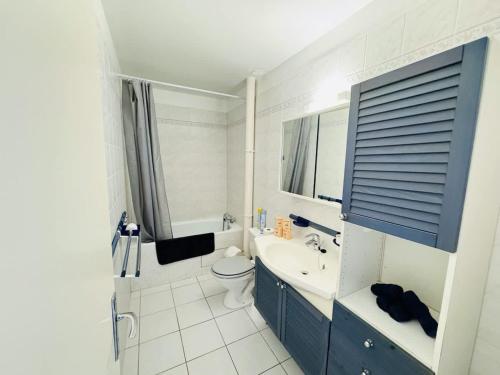 une salle de bain blanche avec des toilettes et un lavabo dans l'établissement Valras-Loc Maison de ville avec terrasse, à Valras-Plage
