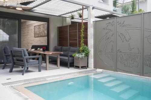 a patio with a pool and a table and chairs at September15 Suites- Meganisi in Meganisi