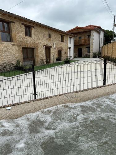a fence in front of a house with snow on the ground at encanto rural en arce by urbanhosting in Arce