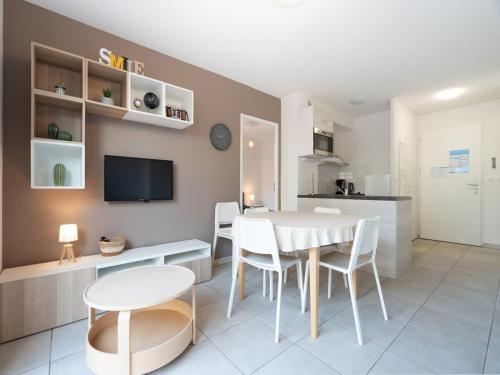 une cuisine et une salle à manger avec une table et des chaises dans l'établissement Valras-Loc La Dune - Evasion Familiale, à Sérignan