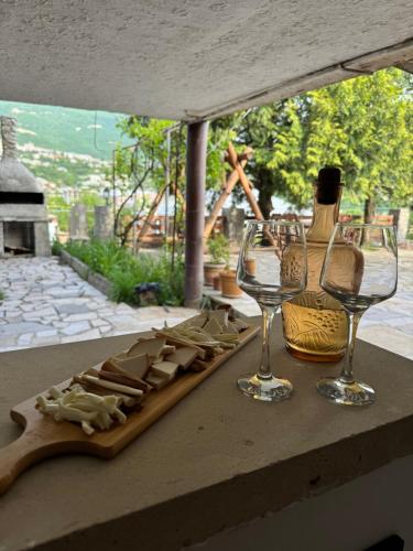 a table with a bottle of wine and two wine glasses at EleGaya Guest house in Ijevan