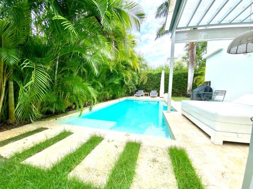 a swimming pool in a yard with a bed and trees at Luxury Villa Pool and BBQ in San Juan Lakes Los Colales RD in Punta Cana