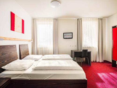 a hotel room with two beds and a desk at Hotel Speyer am Technik Museum in Speyer
