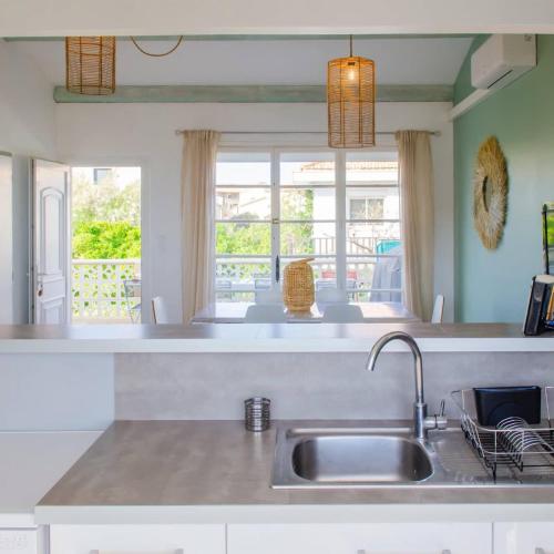 une cuisine avec un évier et une fenêtre dans l'établissement Villa Solera, T3 lumineux, 3 etoiles, 30m plage, à Valras-Plage