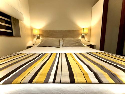 a large bed in a room with two lamps at Waka Lodge - House with garden in Blue Bay