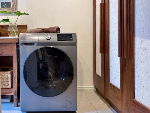 a washing machine sitting in a room next to a door at Waka Lodge - House with garden in Blue Bay