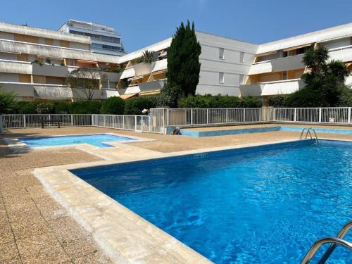 une grande piscine devant un immeuble dans l'établissement Studio spacieux en centre-ville avec piscine - FR-1-716-80, à La Grande Motte