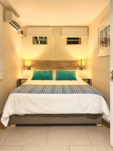 a bedroom with a large bed with blue pillows at Waka Lodge - House with garden in Blue Bay