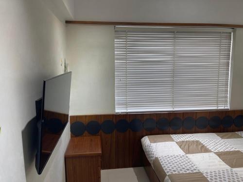 a bedroom with a bed and a window at Tranquil Loft Escape in Pune