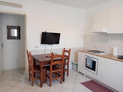 een keuken met een tafel en stoelen en een televisie bij Villa Voltina in Livorno