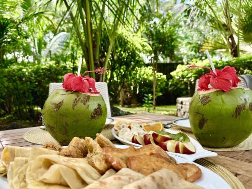 a table topped with plates of food and fruit at Waka Lodge - House with garden in Blue Bay