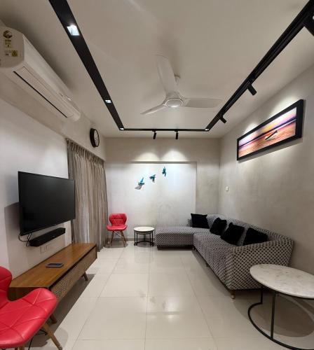 a living room with a couch and a flat screen tv at Tranquil Loft Escape in Pune