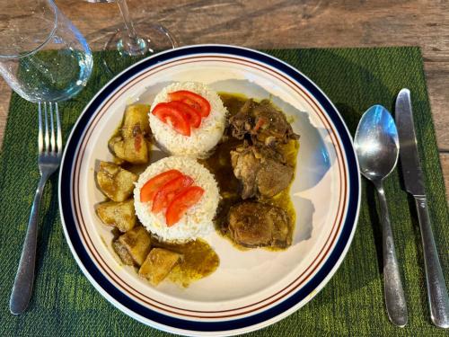 a plate of food with meat and vegetables on a table at Waka Lodge - House with garden in Blue Bay