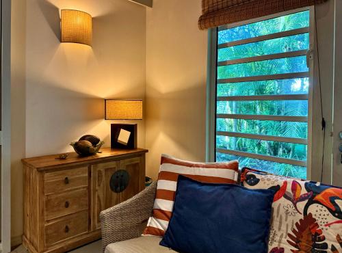 a living room with a couch and a window at Waka Lodge - House with garden in Blue Bay