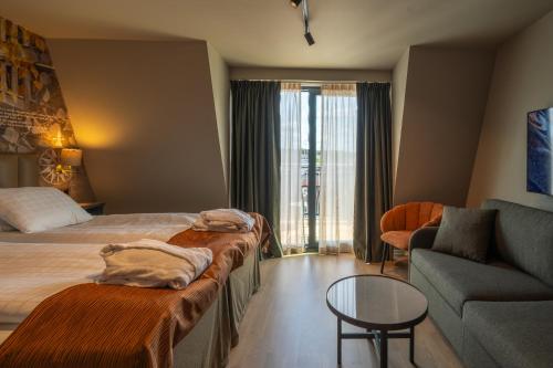 a hotel room with a bed and a couch at Scandic Arvika in Arvika