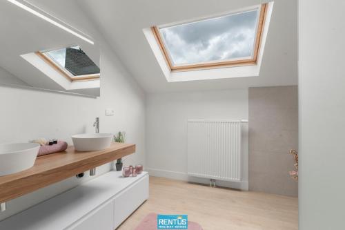 a bathroom with two sinks and a window at Coppietershof - spacious home with garden near historic Bruges in Bruges