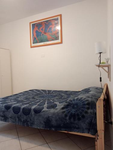 a bed in a room with a picture on the wall at Villa Voltina in Livorno
