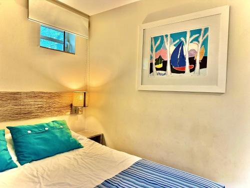 a bedroom with a bed and a painting on the wall at Waka Lodge - House with garden in Blue Bay
