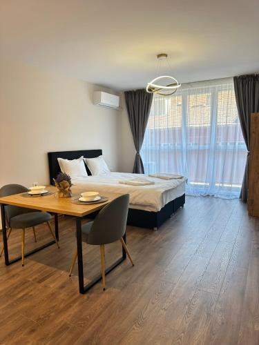 a bedroom with a bed and a table and chairs at Chantrer in Burgas