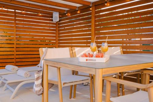 a dining room with a table and two glasses of wine at A'More Preko in Preko