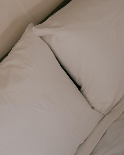 a bed with white sheets and a pillow at Camping Santa Elena in Lloret de Mar
