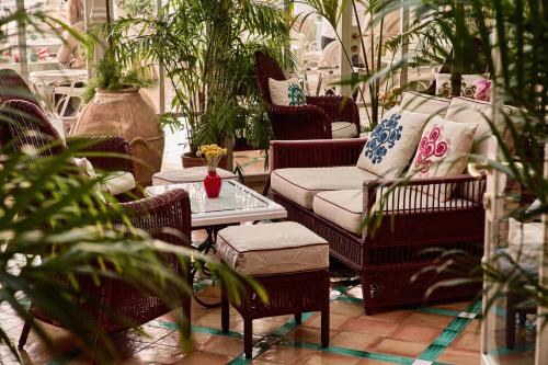 a patio with chairs and a couch and a table at Le Sirenuse in Positano