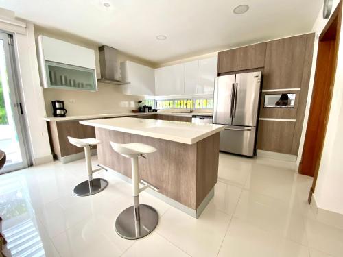 a kitchen with a counter and a refrigerator at Luxury Villa Pool and BBQ in San Juan Lakes Los Colales RD in Punta Cana