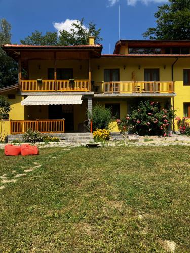 a yellow house with a yard in front of it at Вила Ренесанс Костенец in Kostenets