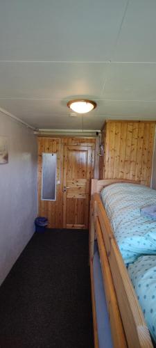 a bedroom with a bed in a room with wooden walls at Mary Rooms in Tromsø