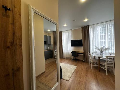 a mirror in a room with a table and a dining room at Smart House Apartments in Lviv