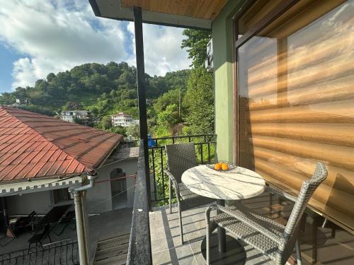 a balcony with a table and chairs on a house at Horizon Hills Cottage- ჰორიზონ ჰილს in Kvariati
