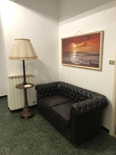 a brown leather couch in a room with a lamp at Casa JEANMARC in Moneglia