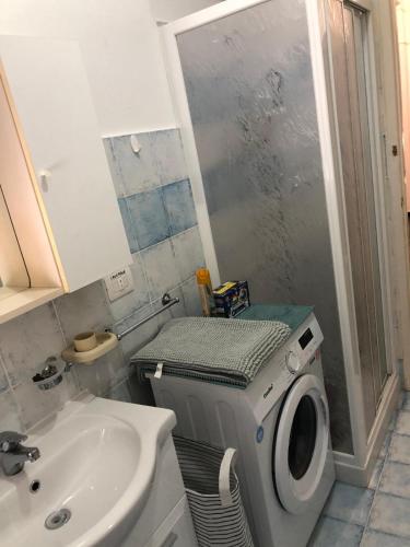 a bathroom with a washing machine next to a sink at Casa JEANMARC in Moneglia