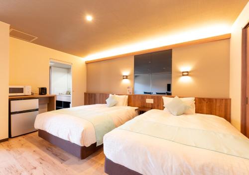 a hotel room with two beds and a kitchen at LiVEMAX RESORT Atami OCEAN in Atami