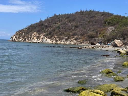 a beach with rocks and a mountain in the background at 707 Chess Loft en Pozos Colorados in Santa Marta