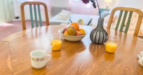 a table with a bowl of fruit and two glasses of orange juice at Hypercentre - Proche Place St Didier in Avignon